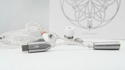 Meze Audio Alba -nappikuulokkeet, valkoinen punottu kaapeli, harmaa USB-C-liitin, valkoiset korvatyynyt, valkoinen tausta geometrisella kuviolla