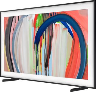 Samsung The Frame TQ55LS03HA-tv i sort med tynd hvid ramme, set i trekvart vinkel, visning af et farverigt abstrakt kunstværk