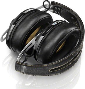 Sennheiser Momentum Wireless sort circumaural hovedtelefoner, set fra venstre profil, liggende på en reflekterende hvid overflade