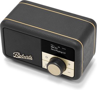 Roberts Revival Petite 2 sort bordradio i sort kunstlæder med kornet struktur og gyldne kanter, perforeret højttalergrill og logo til venstre, digitalt display og stor sort-gylden drejeknap til højre, let skrå perspektivbillede fra forsiden