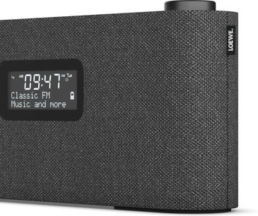 Stalinis radijas Loewe Radio Frequency tamsiai pilkas, tekstilinis priekis su juodu skaitmeniniu ekranu ir ratuku viršuje