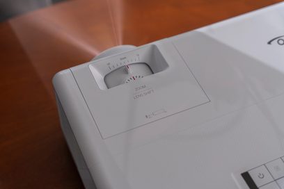 Optoma UHZ50 videoprojektor, set ovenfra, zoom ind på kontrolpanelet med justeringshjul og tænd/sluk-knap
