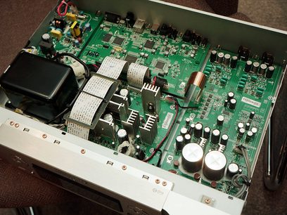 Indvendigt syn af en åben sort Marantz NA-8005, der afslører et grønt printkredsløbskort med talrige elektroniske komponenter