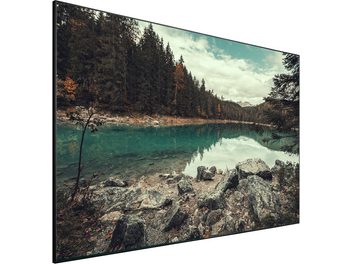 Tela fixa Lumene Movie Palace UHD 4K Ultraslim 300C exibindo uma paisagem florestal e lacustre outonal com rochas em primeiro plano