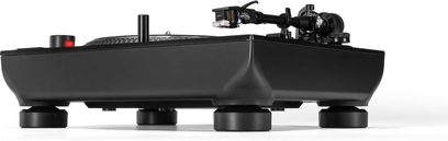 Černý vinylový přehrávač Reloop RP-7 z kovu a plastu, pohled z nízkého bočního úhlu, velké izolované nohy, rýhované rameno a talíř