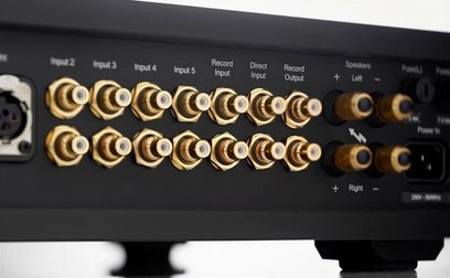 Rega Osiris zwarte stereo hi-fi versterker, close-up achteraanzicht, vergulde RCA audio-ingangen en Record-uitgangen, luidsprekeraansluitingen