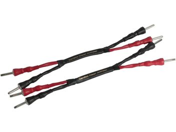 Dos cables de audio rojos y negros con conectores tipo banana de metal plateado en los extremos, de la marca Cardas Clear Jumper