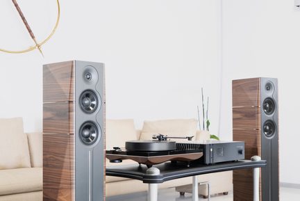 Hi-Fi-Anlage mit Plattenspieler und zwei formschönen Standlautsprechern in Holzoptik in hellem, modernem Wohnzimmer