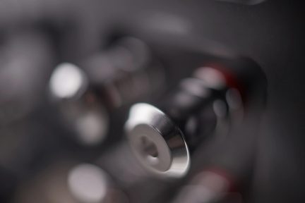 Plan apropiat al butoanelor metalice cilindrice argintii pe un fundal neclar, unghi de vizualizare laterală
