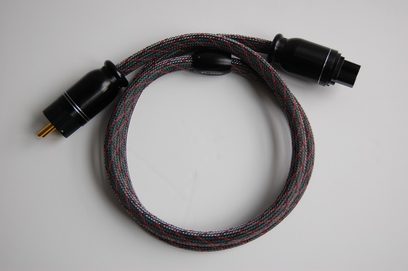 Zwarte gevlochten audiokabel met vergulde RCA-connectoren aan beide uiteinden, opgerold in een spiraal op een witte achtergrond