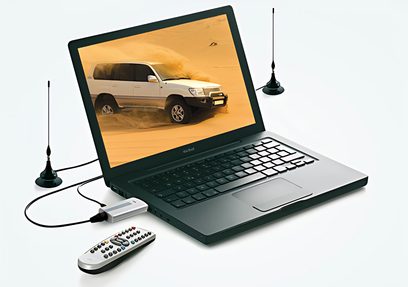 Otevřený černý notebook zobrazující bílý terénní vůz na oranžovém pozadí, s dálkovým ovládáním a dvěma anténami