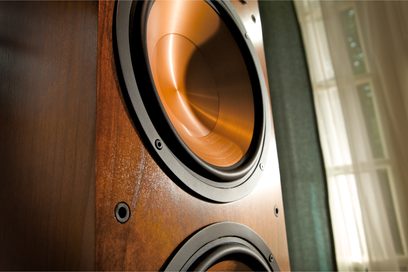 Reproduktorová sestava Klipsch RF-7 MkII v černé barvě, detailní pohled zepředu na basový reproduktor z tmavého dřeva a ozvučnici