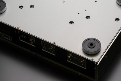 Leitor de CD Marantz CD6007 prateado dourado, vista superior, conectores e botões na frente, superfície metálica, orifícios circulares