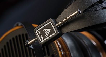 Casque audio Audeze ouvert en bois zébrano foncé, arceau en cuir noir, plaque métallique avec logo "A" sur écouteur droit