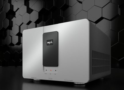 A silver stereo amplifier with a black central panel marked "spl," placed on a black surface with a background of hexagonal patterns