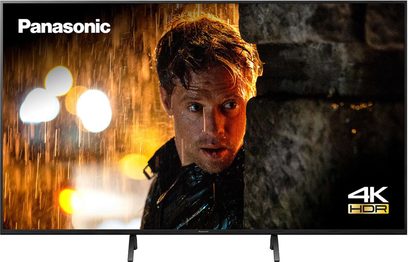 Nærbillede af Panasonic TX-55HX940E-tv, der viser et oplyst, kontrasteret mandligt ansigt med vådt hår og regnvandsdråber