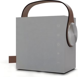 Портативен Bluetooth високоговорител Morel Biggie в бял цвят, кубичен корпус от мат бял пластмас с извита кафява дръжка, широка сребриста странична ръчка, дискретни тактилни икони на предната страна, изглед от три четвърти преден десен ъгъл