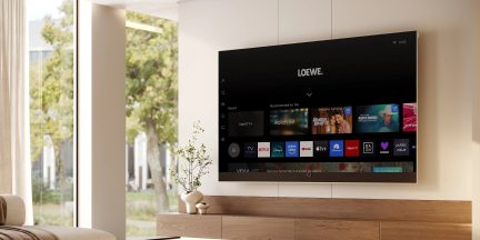 Loewe zwarte grootbeeldtelevisie aan de muur bevestigd in een moderne woonkamer, streaminginterface frontaal weergegeven
