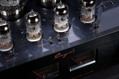 Nærbillede i trekvart vinkel af en Cayin Jazz 80 EL34 sort stereo integreret rørforstærker, børstet metalkabinet med metalliseret topflade, synlige glasrør, indbyggede VU-metre og miniaturekontakter ledsaget af orange serigrafi