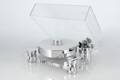 Vinylová hi-fi gramodeska Transrotor Bellini RB330 z pohledu tří čtvrtin zepředu vlevo, základna a kryt z transparentního akrylu jsou zvednuté, masivní kruhový talíř a válcové podpěry z leštěného stříbrného hliníku, rameno pro čtení vpravo