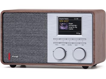 Tischradio Pinell Supersound 201W, rechteckiges Gehäuse aus Nussbaumholz, graues Stoffgitter links und gebürstete Aluminiumfront rechts mit Farbdisplay, fünf schmale Tasten und zwei große gerändelte Drehregler, frontale Ansicht leicht perspektivisch