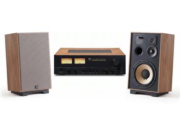 İki VU metreli siyah NAD amplifikatör ve biri gri ızgaralı, diğeri görünür hoparlör sürücülerine sahip iki kahverengi hoparlörden oluşan hi-fi seti