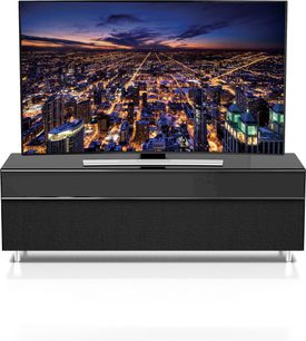 Sort TV-møbel med fladskærm, der viser et natligt luftfoto af en stor, oplyst storby med tætliggende højhuse