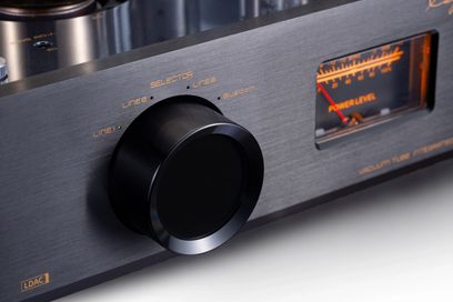 Cayin Jazz 100 svart integrert stereorørforsterker, nærbilde i trekvart profil, frontpanel i sort børstet aluminium med stor rund sort dreieknapp, oransje bakbelyst analogt VU-meter og gyldne påskrifter