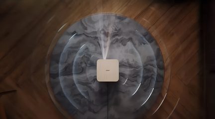 Diffuseur d’huiles essentielles carré effet bois clair, vapeur blanche, vue de dessus sur table ronde marbrée