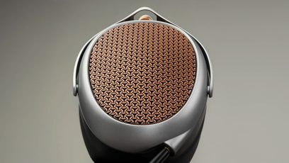 Åbent, kablet hi-fi-hovedtelefon Meze Audio Poet, nærbillede af bagsiden af en ørekop med kobberfarvet perforeret metalgitter