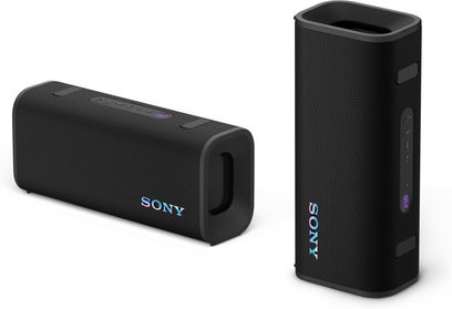 Cassa Bluetooth portatile Sony ULT Field 3 nera con rivestimento in tessuto acustico, a forma di parallelepipedo con angoli arrotondati e logo Sony iridescente, radiatori passivi rettangolari sui lati corti e fascia di pulsanti in gomma sulla parte superiore o sul fianco, presentata in prospettiva a tre quarti con un esemplare sdraiato e uno in piedi
