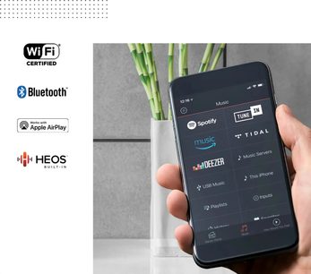 Svart Denon Home 550 soundbar, framifrån, hållen i en hand som håller en smartphone med Spotify-appen öppen