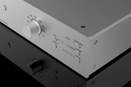 HiFi phono-forforsterker i sølv sett i trekvart vinkel med stor sentralknapp og innstillinger for Input, Loading og Gain