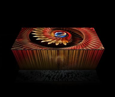 Gran pantalla plana rectangular negra con marco metálico fino y superficie de vidrio, presentada en vista isométrica y mostrando un patrón fractal rojo y dorado centrado alrededor de un orbe azul
