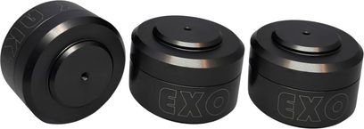 Drei Aktyna EXO Antivibrationsdämpfer aus mattschwarzem Metall, kompakte zylindrische Form mit leicht vertiefter Oberseite und seitlicher Beschriftung, Ansicht aus drei Vierteln
