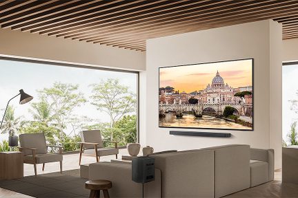 Stue med sofa, lænestole, sofabord, soundbar under et stort fladskærms-tv, der viser et maleri af Peterskirken i Rom