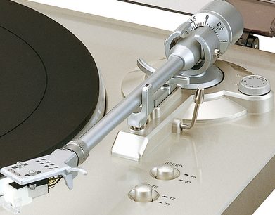 Platine vinyles hi-fi Denon DP-300F argent, vue de dessus en gros plan sur le bras de lecture et la cellule