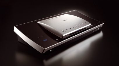 Sølvfarvet Yamaha DVX-1000 hjemmebiografsystem, set forfra i et skråt perspektiv, blå LCD-skærm der viser oplysninger