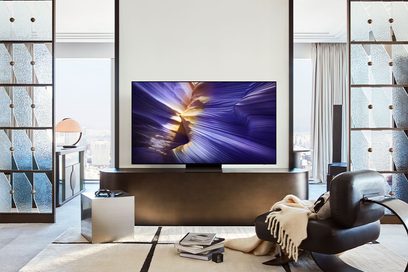Televizor s plochou obrazovkou 65 palců, ultra tenký matný černý kovový rám, hladký skleněný displej zobrazující abstraktní fialovo-zlatý obraz, pohled zepředu na černém centrálním podstavci