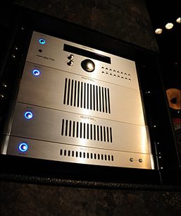 Rotel RB-1572 Leistungsverstärker in Schwarz, Frontansicht, 4 leuchtend blaue Knöpfe, Metallgitter, Großaufnahme