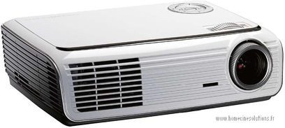 Optoma HD65 hvid videoprojektor, forfra med linse, ventilationsriste og kontrolpanel, set fra tre kvart vinkel