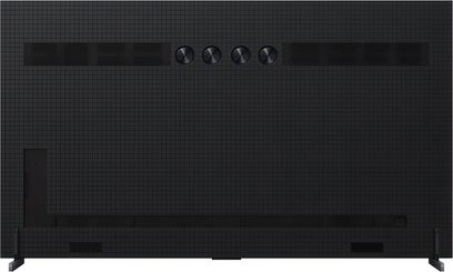 TCL 98X11K højopløsnings-tv i sort plast og metal med gittertekstur, set bagfra med fire centrale skiver, horisontale ventilationsgitre, rektangulære adgangspaneler og vinklede fødder