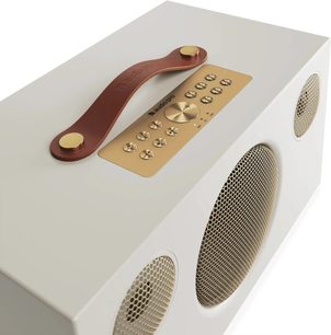 Altın renkli ızgaraları, üst kısmında kontrolleri ve kahverengi taşıma sapı bulunan bej Audio Pro C10 MKII W Classic akıllı hoparlör