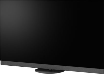 Panasonic TV-65Z95B -teräväpiirtotelevisio, musta, ohut metallikehys, tummanharmaalla kankaalla verhoiltu alakaiutin ja pyöreä keskijalusta, kolmen neljäsosan etunäkymä