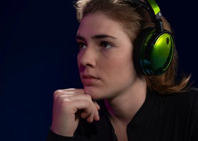 Trådløse hifi-hovedtelefoner Audeze Maxwell Xbox Wasabi på hovedet, venstre profil, hånd under hagen, mørkeblå baggrund