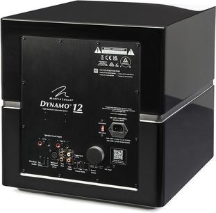 Dynamo 12 subwoofer i sort højglans, set bagfra i vinkel, rektangulært tilslutningspanel med hvide inskriptioner og stik.