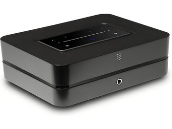 Amplificador hi-fi integrado estéreo BlueSound Powernode 2025 (N331) negro mate de aluminio, carcasa rectangular con bordes redondeados vista en perspectiva frontal derecha, panel táctil negro brillante incrustado en la parte superior con iconos blancos y círculo azul luminoso, logotipo frontal y salida de auriculares de 3,5 mm