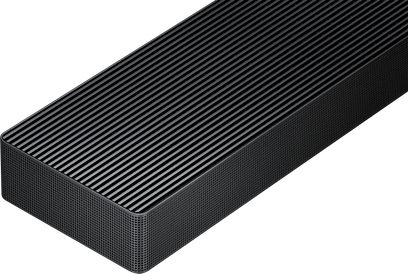 Černý kovový obdélníkový soundbar, pohled ze tří čtvrtin shora, horní část s rovnoběžnými žebry a boční strany s pravidelnou perforovanou mřížkou