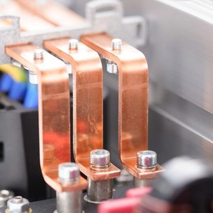 Detailní záběr z pohledu tři čtvrtě na tři měděné vodivé tyče upevněné šrouby, součást síťové lišty Inakustik AC-3200 Filter Analog SCHUKO