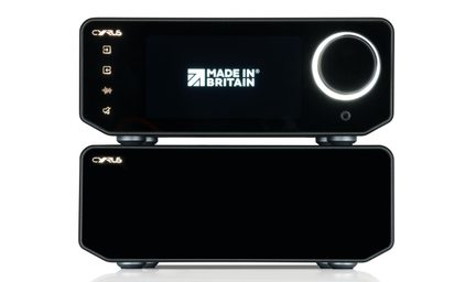 Divi melni metāla hi-fi korpusi, sakrauti viens uz otra, skats no priekšpuses, ekrāns MADE IN BRITAIN, liels izgaismots vadības ritenis, austiņu ligzda